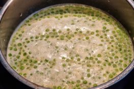 Grüne Erbsensuppe köchelt im Topf