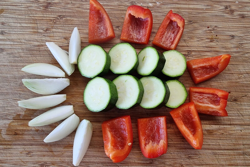 Die Hähnchenfilets in ca. 2,5 cm große Stücke schneiden, in eine Schüssel geben.