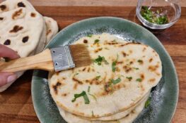 Indisches Fladenbrot mit Butter bestreichen