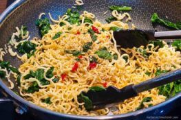 Zubereitung der Mie Nudeln mit Spinat und Cashewkernen in der Pfanne
