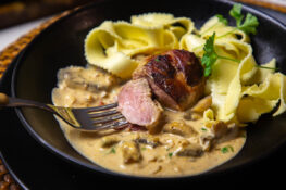 schweinefilet im speckmantel fertig zubereitet auf dem Teller