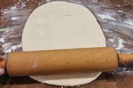 Der Flammkuchenteig wird ausgerollt