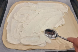 Crème fraîche wird auf den Flammkuchen Boden gestrichen