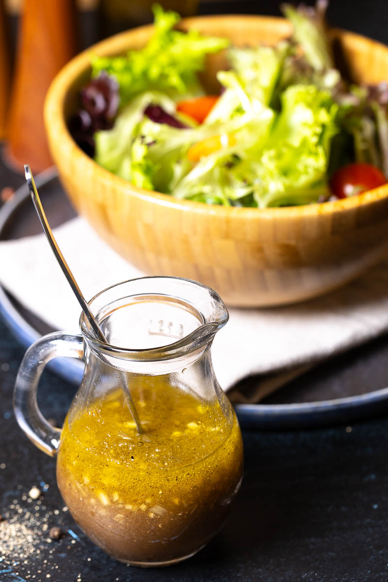 Vinaigrette Salatdressing mit einer Schüssel Salat