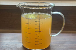 Apfelsaft und Wasser für das Holunderblüten Gelee im Messbecher