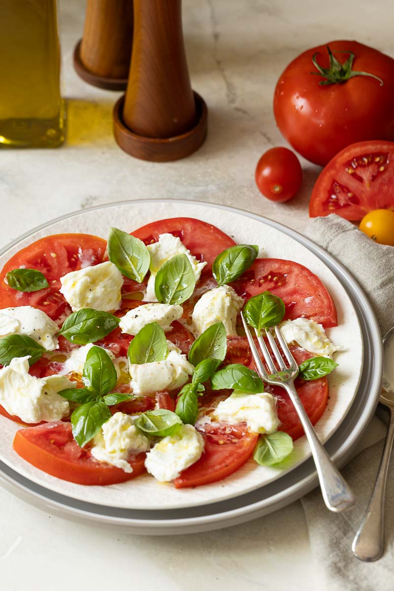 Caprese Salat auf weißem Teller mit Gabel