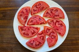 Tomaten aufgeschnitten auf weißem Teller für den Caprese